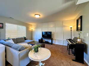 Carpeted living room with accent wall and a textured ceiling
