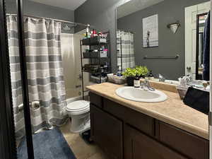Bathroom with light tile patterned floors, vanity, and shower / tub combo