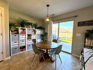 Tiled dining area featuring baseboards and a mountain view