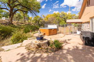 View of patio / terrace with a hot tub and a gate