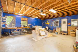 Misc room featuring a workshop area, unfinished concrete floors, and a garage