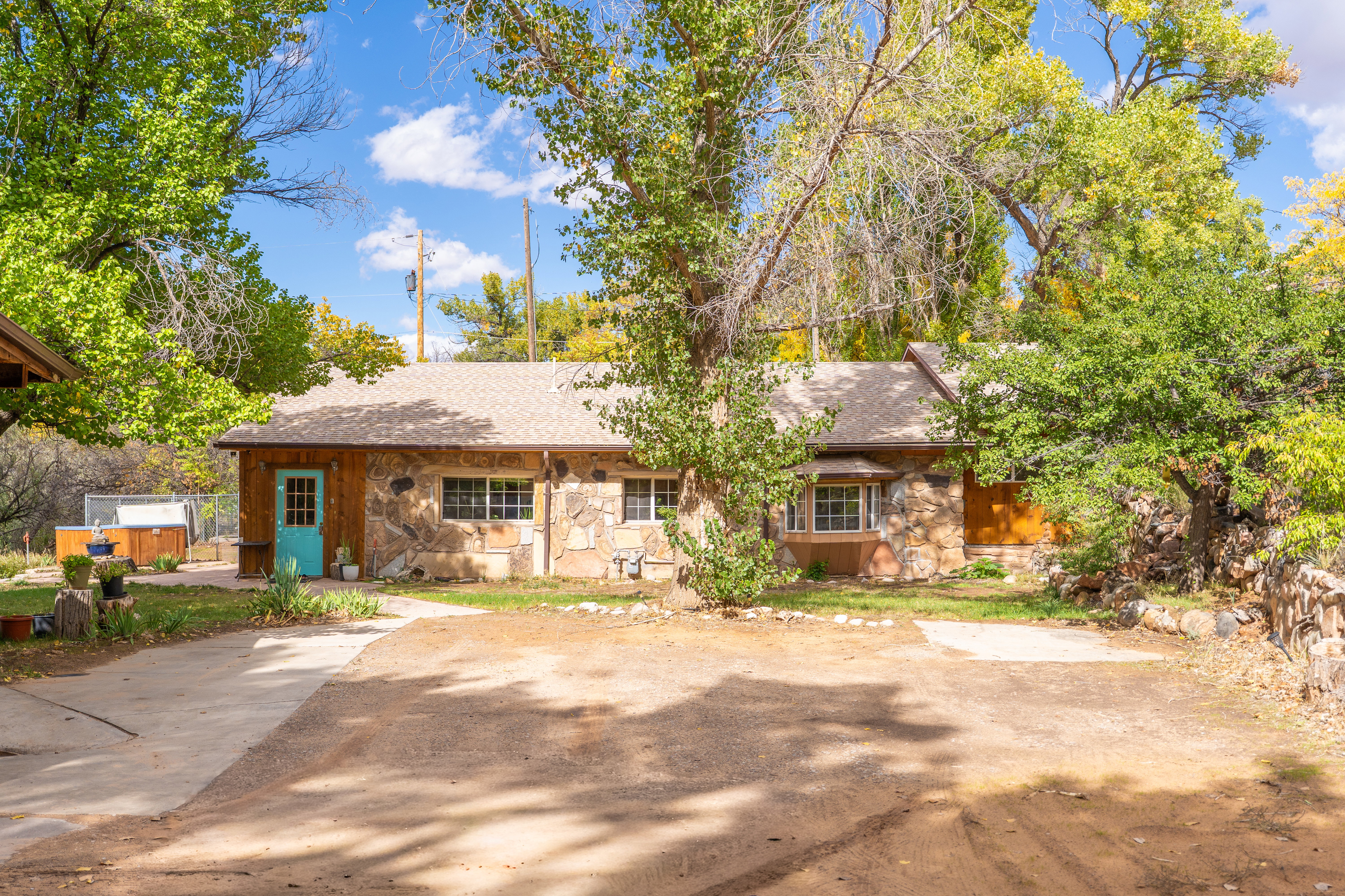 View of front of home featuring stone siding and a shingled roof