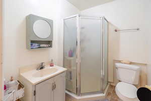 Full bath with vanity, a shower stall, and light tile patterned floors
