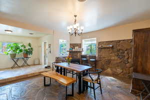 Dining area featuring stone floors and a chandelier
