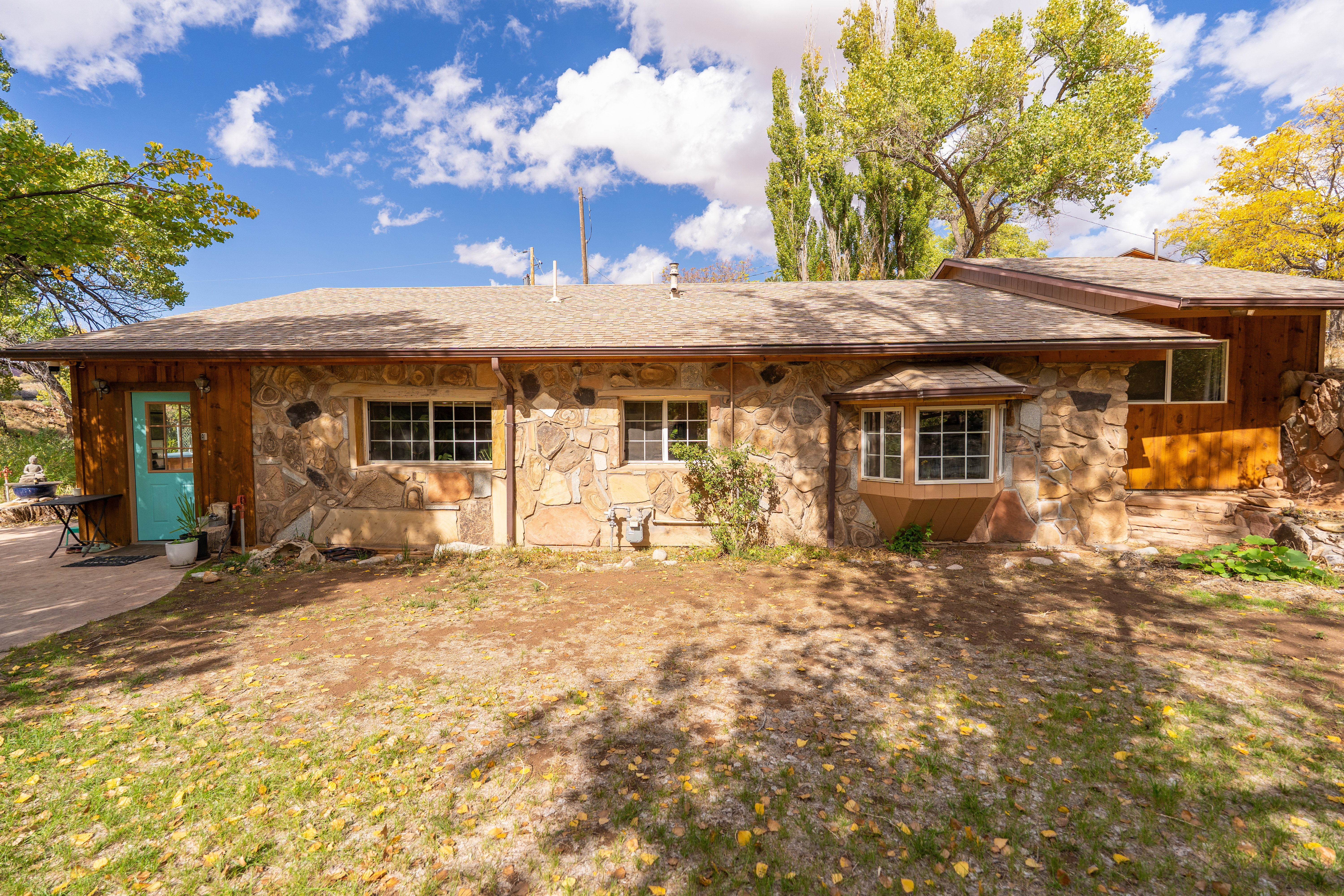 Rear view of house with stone siding and roof with shingles