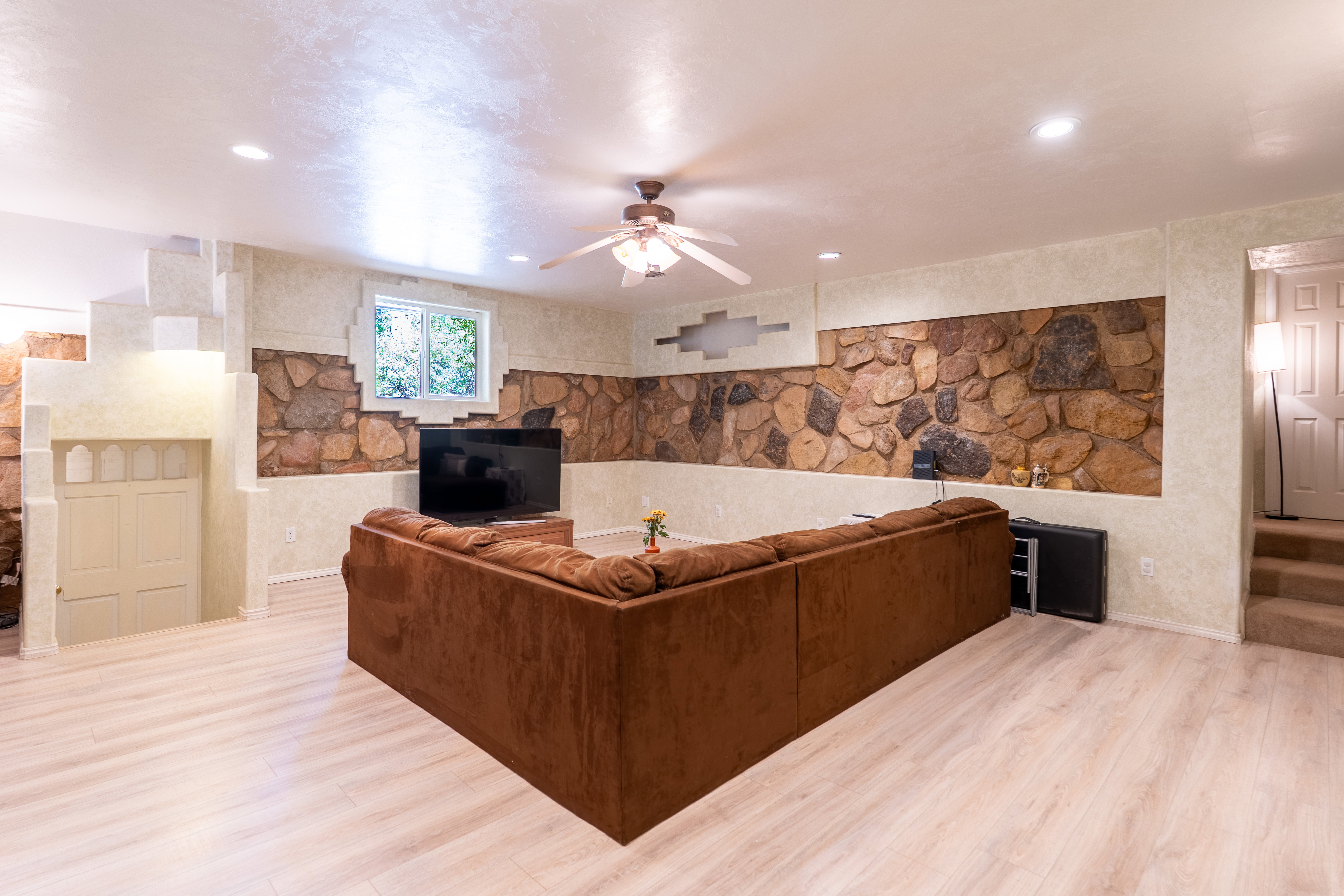 Living room with ceiling fan, light wood-style flooring, and recessed lighting