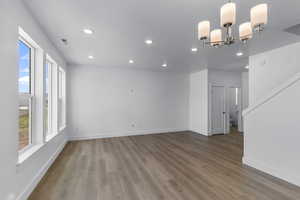 Unfurnished living room featuring recessed lighting, light wood finished floors, and a chandelier