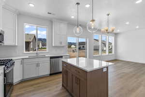 Kitchen featuring white cabinets, decorative backsplash, light wood-type flooring, and recessed lighting