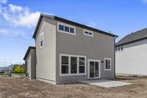 Back of property with a patio and stucco siding