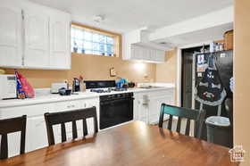 Kitchen featuring white cabinets, range, white microwave, and light countertops