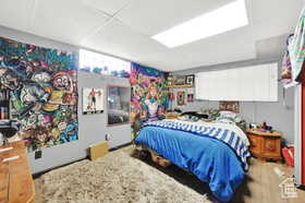 Bedroom with a paneled ceiling and wood finished floors