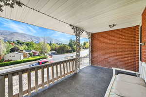 Covered porch featuring a mountain view