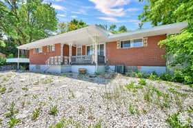 Ranch-style home featuring a porch and brick siding