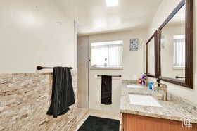 Full bath featuring double vanity, tile patterned flooring, and a stall shower