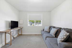 Carpeted living area featuring baseboards