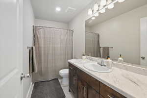 Full bath featuring vanity, curtained shower, and light tile patterned floors