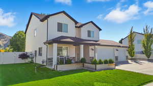 View of front of home featuring covered porch, driveway, stone siding, a garage, and a mountain view