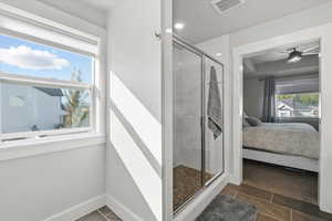 Ensuite bathroom featuring dark tile patterned flooring, a shower stall, ceiling fan, and recessed lighting