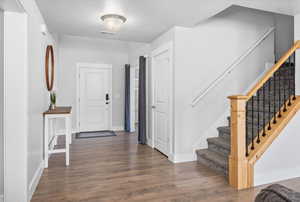 Foyer with wood finished floors and stairway