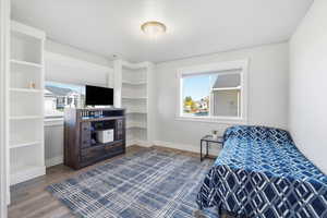 Bedroom featuring dark wood-style floors and baseboards