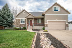 View of front of home featuring covered porch, stone siding, stucco siding, concrete driveway, and roof with shingles