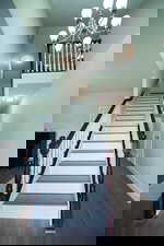 Stairs featuring wood finished floors and a chandelier