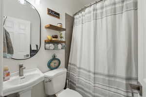 Bathroom with a shower with curtain and toilet