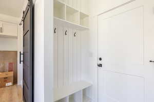 Mudroom with a barn door and light wood-type flooring