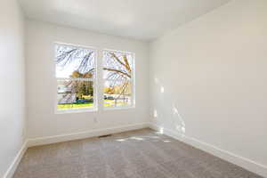 Spare room with carpet and baseboards