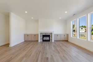 Unfurnished living room with a fireplace, recessed lighting, and light wood-style flooring