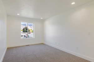 Spare room with light carpet and recessed lighting