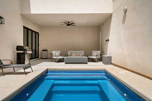 View of swimming pool featuring grilling area, a pool, and a ceiling fan