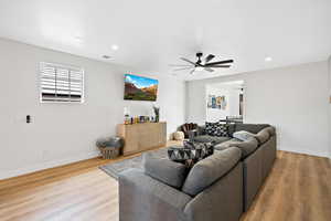 Living area featuring light wood-style floors, a ceiling fan, and recessed lighting