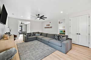Living area with light wood-style flooring, recessed lighting, and ceiling fan