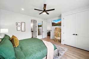 Bedroom with light wood-type flooring, ceiling fan, recessed lighting, ensuite bathroom, and a closet