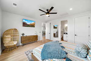 Bedroom featuring light wood-style flooring, attic access, ceiling fan, recessed lighting, and ensuite bath