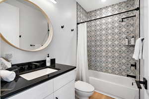 Bathroom featuring shower / bath combo with shower curtain and vanity