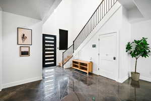 Foyer featuring a high ceiling and stairs