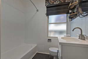 Full bath featuring tile walls, vanity, and bathing tub / shower combination