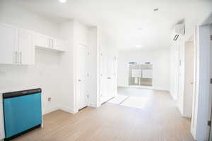 Rntry - light wood-style flooring, and a wall mounted AC