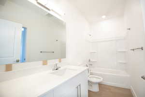 Full bath featuring vanity,  shower combination, and light wood-style floors