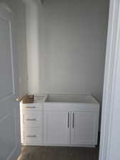 Full bath featuring a garden tub and dark wood-style floors