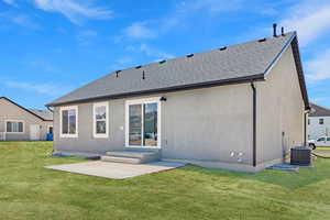 Back of house with a yard, roof with shingles, a patio area, and stucco siding