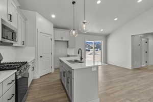 Kitchen featuring stainless steel appliances, recessed lighting, tasteful backsplash, decorative light fixtures, and white cabinetry