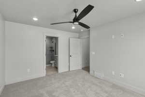 Unfurnished bedroom with recessed lighting, ceiling fan, light colored carpet, and ensuite bath