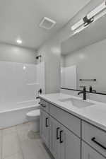 Bathroom with vanity, light tile patterned floors, and tub / shower combination