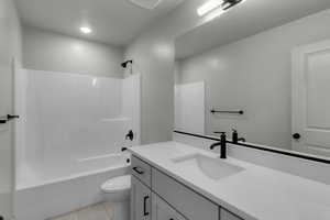 Full bath with bathtub / shower combination, vanity, and light tile patterned floors