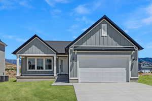 View of front of property featuring board and batten siding, an attached garage, driveway, a mountain view, and roof with shingles