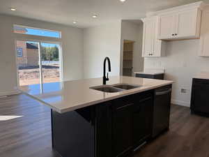 Kitchen featuring white cabinetry, dark cabinetry, dark wood finished floors, light stone counters, and recessed lighting