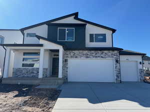 Contemporary home featuring stone siding, stucco siding, concrete driveway, and an attached garage